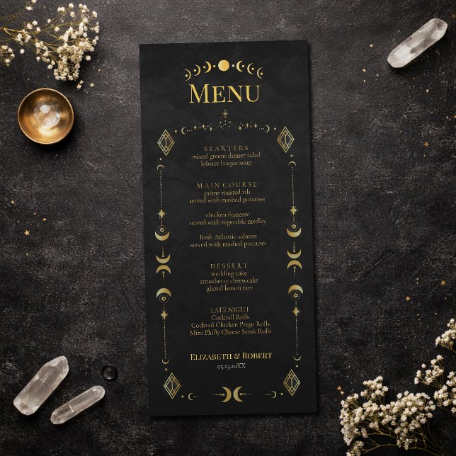Carte de Menu de Mariage Céleste Gothique Noir et  (Celestial Gothic Black and Gold Wedding Menu Card on an elegant dark table with dry flowers)