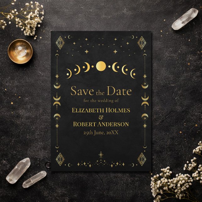 Carte de mise en garde céleste gothique noir et or (Celestial Gothic Black and Gold Save the Date Card on an elegant dark table with dry flowers)
