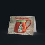 Carte de Noël de la Coupe Snowman<br><div class="desc">OEuvre d'art originale avec ma photo originale d'une tasse de style vintage avec un bonhomme de neige sur elle ; stylée avec un effet imaginaire aquarelle pour un aspect enneigé illustré et fantaisiste. L'avant de la carte indique "Ayez une Coupe de Cheer!" et l'intérieur de la carte indique "Espérons que...</div>