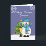 Carte de Noël Grandson Snowman<br><div class="desc">Célébrez Noël avec votre petit-fils avec cette adorable carte avec un bonhomme de neige avec un foulard bleu, des mitaines et un casquette tenant une étoile et un sapin décoré derrière lui. Il se tient dans la neige avec un arrière - plan bleu foncé et un grand flocon de neige...</div>