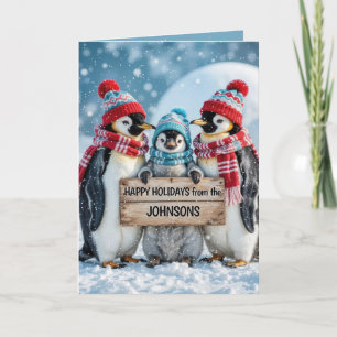 Carte Penguins de famille de Noël avec un panneau en boi