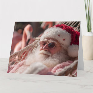 Carte Père Noël se détendant dans un hamac portant des l