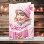 Carte Petite fille mignonne en rose Noël rétro<br><div class="desc">Jolie carte de Noël aquarelle. Adorable petite fille vintage en casquette d'hiver tenant une boîte cadeau rétro en rose.</div>