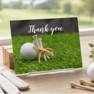 Carte Postale Balle de golf et tee sont sur de l'herbe verte mer