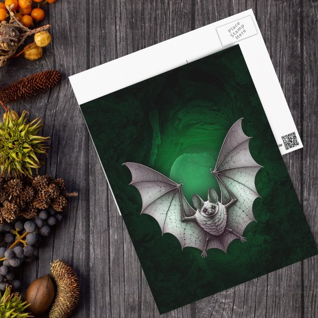 Carte Postale Chauve-souris blanche sinistre grotte verte lumine (Eerie flying white bat green glowing cave on black Halloween postcard.)