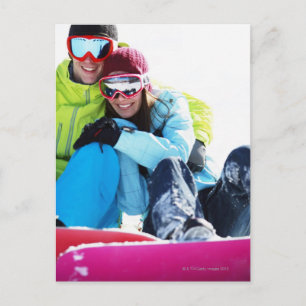 Carte Postale Couples de surfeur se reposant sur la neige