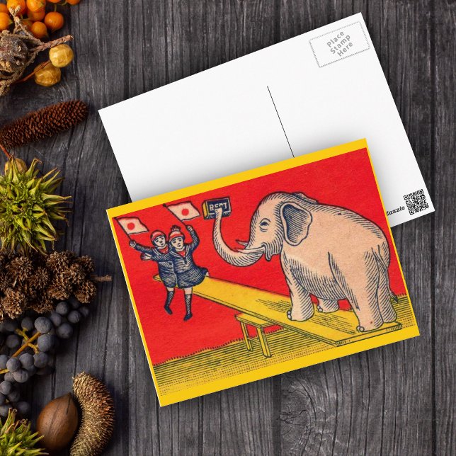 Carte Postale Eléphant sur la scie avec des enfants caméra (Elephant on seesaw with children waving Japanese flags on red and yellow postcard.)
