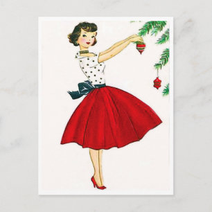 Carte Postale Jeune femme en robe rouge décorant l'arbre de Noël