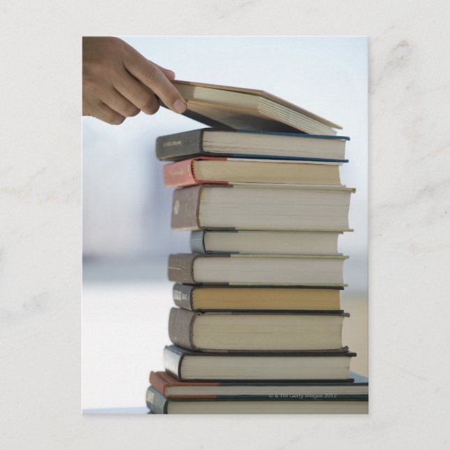 Carte Postale La main de l'homme prenant un livre d'une pile de (Devant)