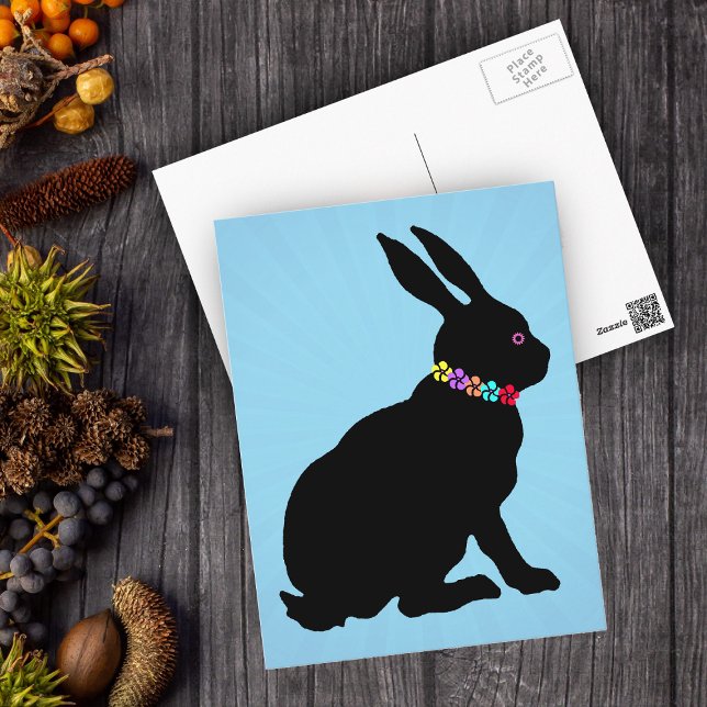 Carte Postale Lapin noir assis en Silhouette Jolie Fleurs (Black silhouette sitting Easter or Spring Time rabbit wearing flowers on blue postcard.)