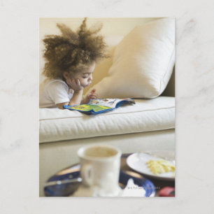 Carte Postale Livre de lecture de garçon de métis sur le sofa