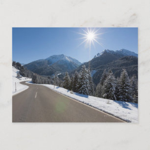 Carte Postale Route vide idyllique à travers un paysage hivernal