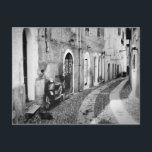 Carte Postale Scooter dans une rue en Italie en noir et blanc<br><div class="desc">Photo carte postale d'un scooter vintage garé devant une maison dans une rue pavée d'une ville en Italie en noir et blanc élégant.</div>