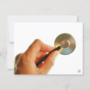 Carte Postale Stéthoscope dans une main devant un hôpital.