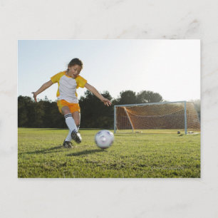 Carte Postale Une jeune fille jouant au football sur un terrain
