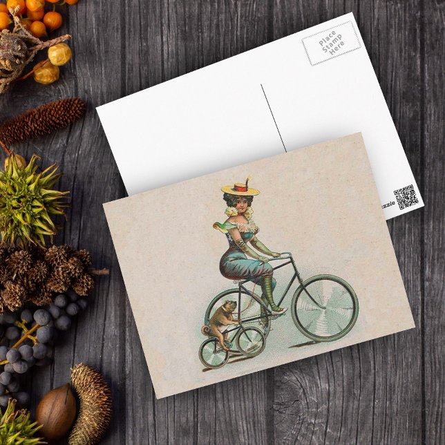 Carte Postale Vélo vintage Victorien Lady Chien (Victorian lady riding a bicycle beside her bulldog riding a bicycle on a tan postcard.)