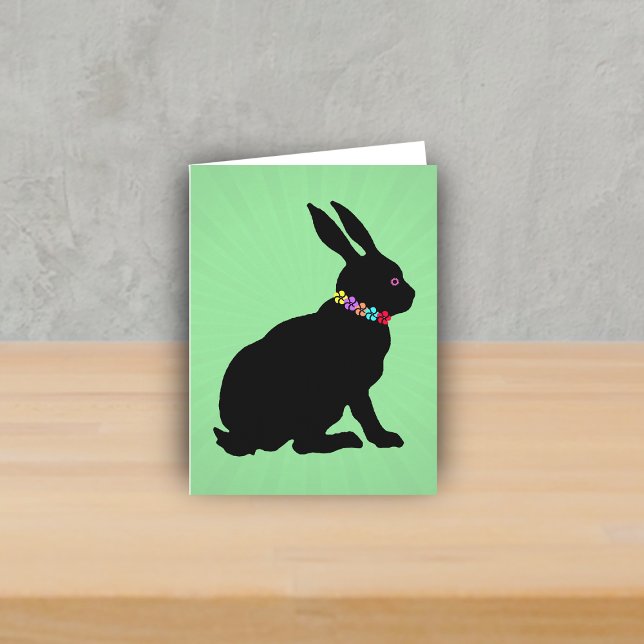 Carte Profil latéral assis Fleurs de lapin noir Oeil ros (Sitting black silhouette bunny wearing colourful flowers on green Spring or Easter note card.)