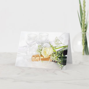 Carte rose blanche sur bouteille de champagne aux perles