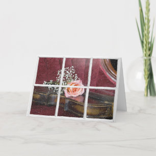 Carte rose sur violon dans la fenêtre avec pluie