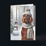 Carte Setter irlandais de Noël avec Snowman<br><div class="desc">Un chien portant un casquette tricoté gris et une écharpe se tient dans une forêt enneigée à côté d'un bonhomme de neige pour Noël</div>