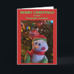 Carte Snowman Christmas Grandson<br><div class="desc">Joyeux Noël à Notre merveilleux petit-fils est écrit sur le devant de la carte de voeux de Noël en texte vert sur arrière - plan rouge. Cheery Snowman accroché à la branche d'arbre de lumières colorées avec un ornement blanc rouge brillant en arrière - plan. La carte peut être personnalisée...</div>