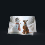 Carte Snowman de Noël avec chien de couture irlandais<br><div class="desc">Un bonhomme de neige et un chien de l'Irish Setter,  tous deux portant des foulards,  partagent un moment de compagnie dans une forêt enneigée</div>