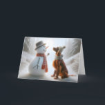 Carte Snowman de Noël avec chien de couture irlandais<br><div class="desc">Un bonhomme de neige et un chien de l'Irish Setter,  tous deux portant des foulards,  partagent un moment de compagnie dans une forêt enneigée</div>