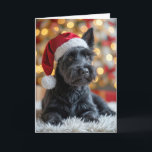Carte Terrier écossais de Noël à la fourrure<br><div class="desc">Un chien écossais en fer blanc vêtu d'un chapeau de Père Noël est assis sur un tapis moelleux devant un sapin de Noël festif orné de lumières. Le texte peut être modifié.</div>