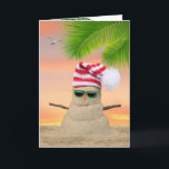 Carte Tropical Christmas Sand Snowman<br><div class="desc">Tropical "bonhomme de neige" dans le sable avec casquette à rayures et lunettes de soleil sur le sable avec ciel couché de soleil.</div>
