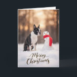 Cartes Pour Fêtes Annuelles Boston Terrier Christmas Snowman<br><div class="desc">A charming winter holiday scene featuring a Boston Terrier sitting in fresh snow beside a cheerful little snowman wrapped in a bright red scarf. Soft golden winter light and gently falling snow create a peaceful seasonal moment that highlights the expressive face and playful personality Boston Terriers are known for. Perfect...</div>
