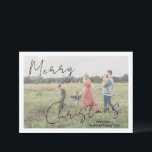 Cartes Pour Fêtes Annuelles Photo moderne Script rustique élégant<br><div class="desc">Carte de Noël photo moderne avec un design simple et minimal avec "Joyeux Noël" dans un élégant script rustique noir sur votre photo préférée avec votre nom de famille. Le modèle comprend une superposition blanche pour aider le texte à se démarquer sur votre photo et peut être supprimé dans l'outil...</div>