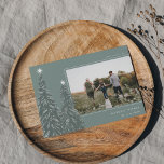 Cartes Pour Fêtes Annuelles Pins neigeux | Élégante photo de Noël<br><div class="desc">Un design moderne et élégant de cartes de vacances de Noël avec une photo horizontale sur un arrière - plan vert orné de pins chargés de neige et surmonté d'étoiles blanches. Personnalisez avec votre salutation de vacances personnalisée,  le nom de famille et l'année.</div>