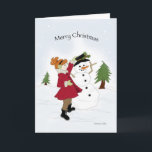 Cartes Pour Fêtes Annuelles Snowman et petite fille<br><div class="desc">Petite fille en manteau rouge habillant un bonhomme de neige dans la neige</div>