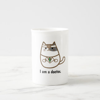 Chat mignon dans la tasse d'uniforme de docteur