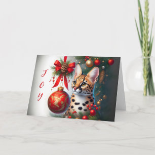 Chat Serval à côté de la carte de Noël de l'orneme