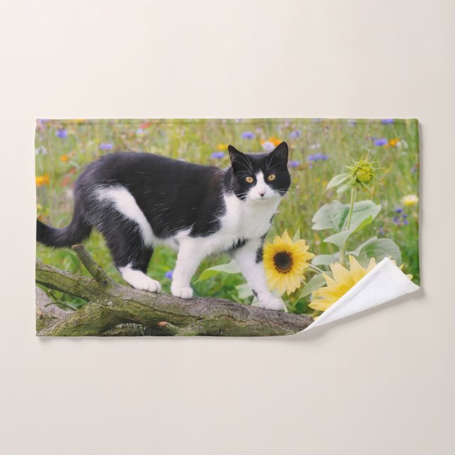 Chat tuxedo mignon sur une branche d'arbre avec de (Serviette à main)
