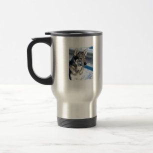 Chien de traîneau dans la tasse de voyage de neig