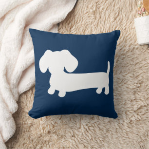 Chiot blanc de teckel sur le milieu de coussin de