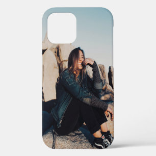 Coque iPhone 12 Femme assise et souriante portant un pantalon noir