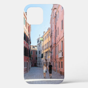 Coque iPhone 12 Femme en veste noire marchant sur le trottoir dans