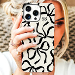 Coque iPhone 16 Pro Max Monogramme Liquide Et Bow Noir<br><div class="desc">Habille ton téléphone avec style avec ce boîtier en ivoire et noir chic et tendance ! Doté d'un motif ludique d'arcs dessinés à la main et personnalisé avec votre monogramme, ce coque est le parfait mélange de mode et de fonction. Fabriqué à partir de matériaux durables pour protéger votre téléphone...</div>