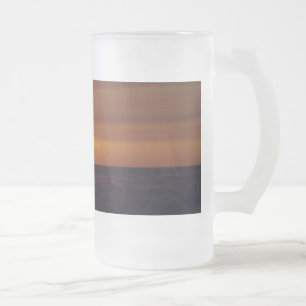 Coucher du soleil sur la tasse givrée par plage