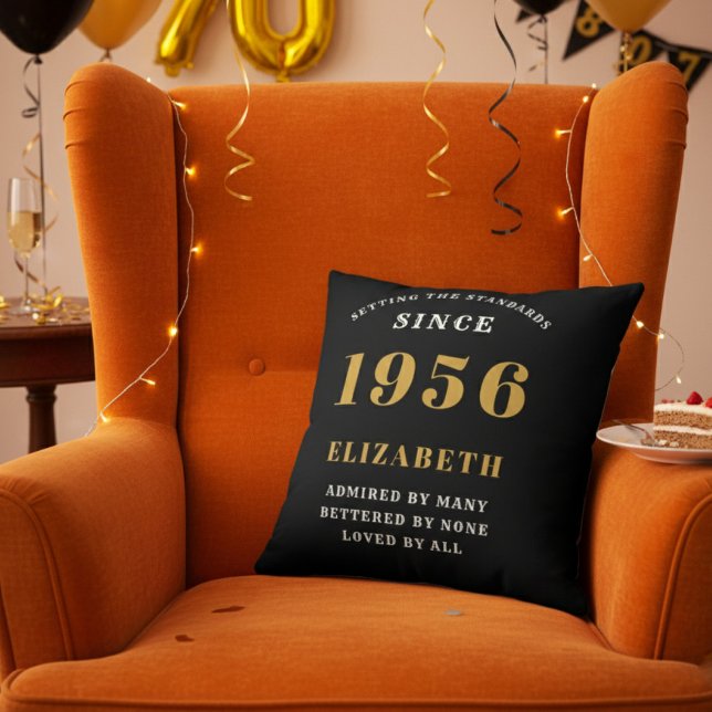 Coussin 70th Birthday Gift Personalized 1956 Black Gold (Personalized 70th birthday throw pillow on an orange velvet wingback chair)