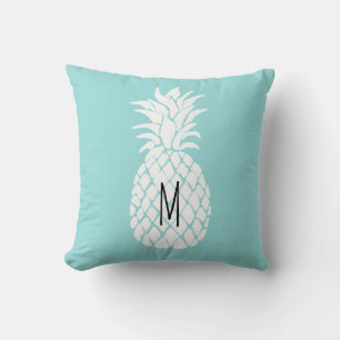 Coussin ananas monogramme sur moquette pastel bleu