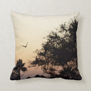 Coussin arbres et oiseau de vol contre le coucher du