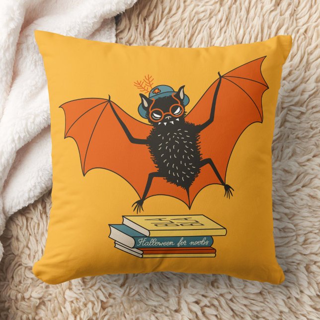 Coussin Chauve-souris lectrice | Bibliothécaire fantaisist (yellow pillow with a funny cartoon bat librarian with eyeglasses and hat flying over books)