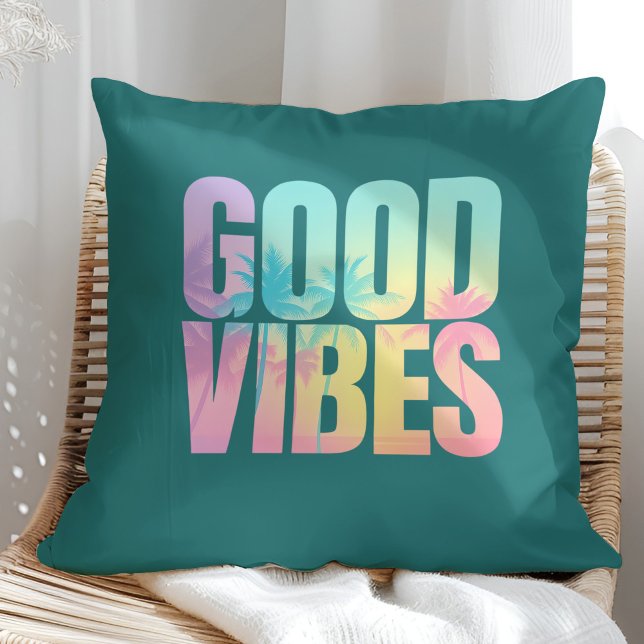 Coussin Citation Tropicale "Good Vibes" ("Good Vibes" Vibrant Tropical Quote Throw Pillow on a boho sunny rattan chair.)