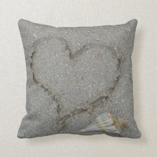 Coussin coeur dans le sable avec coquille