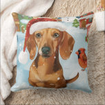 Coussin Dachshund Winter Wonderland Christmas Joy<br><div class="desc">Ce design festif reflète l'esprit joyeux de la période des fêtes, avec un adorable petit portant un chapeau de Père Noël. Le chien est niché dans un pays des merveilles hivernales, avec un bonhomme de neige, un sapin de Noël décoré et des cadeaux joliment emballés. Les flocons de neige tombent...</div>