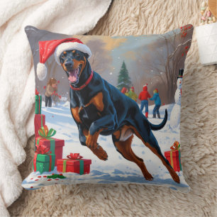 Coussin Doberman courant dans la neige avec un chapeau de